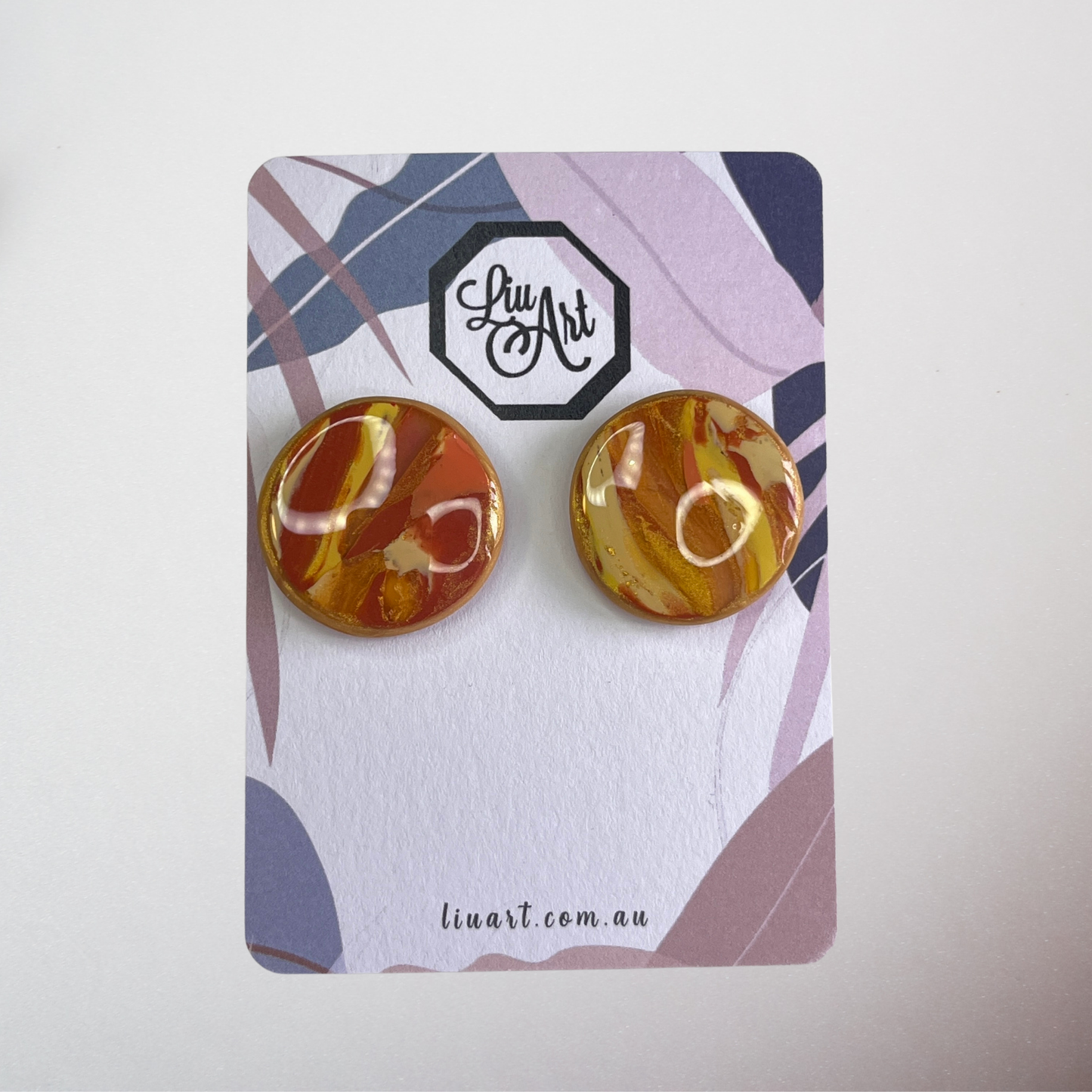 Pair of marbled orange earrings on a branded card with 'liuart' logo.