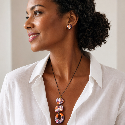 Woman wearing a white shirt and colorful necklace with a neutral background
